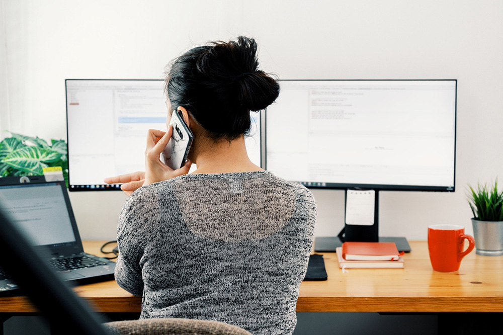 Woman sitting at computer back turned to the camera