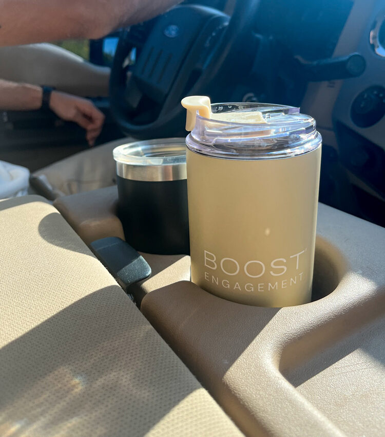 Boost Engagement branded beige cup in car