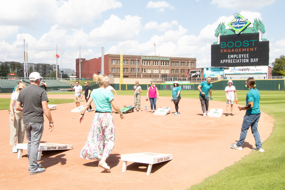 Boost Engagement employees playing cornhole on Dayton Dragons field