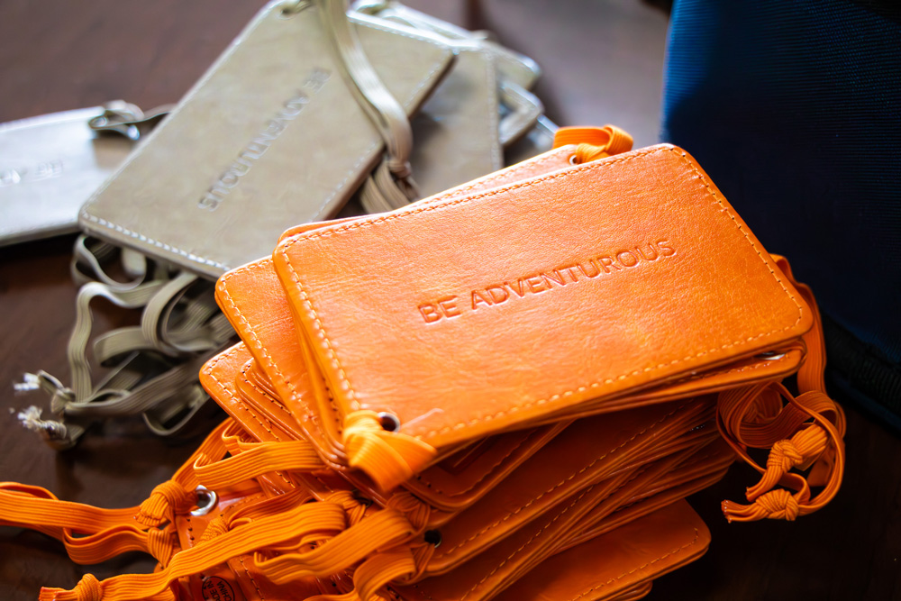 Orange luggage tags that say Be Adventurous